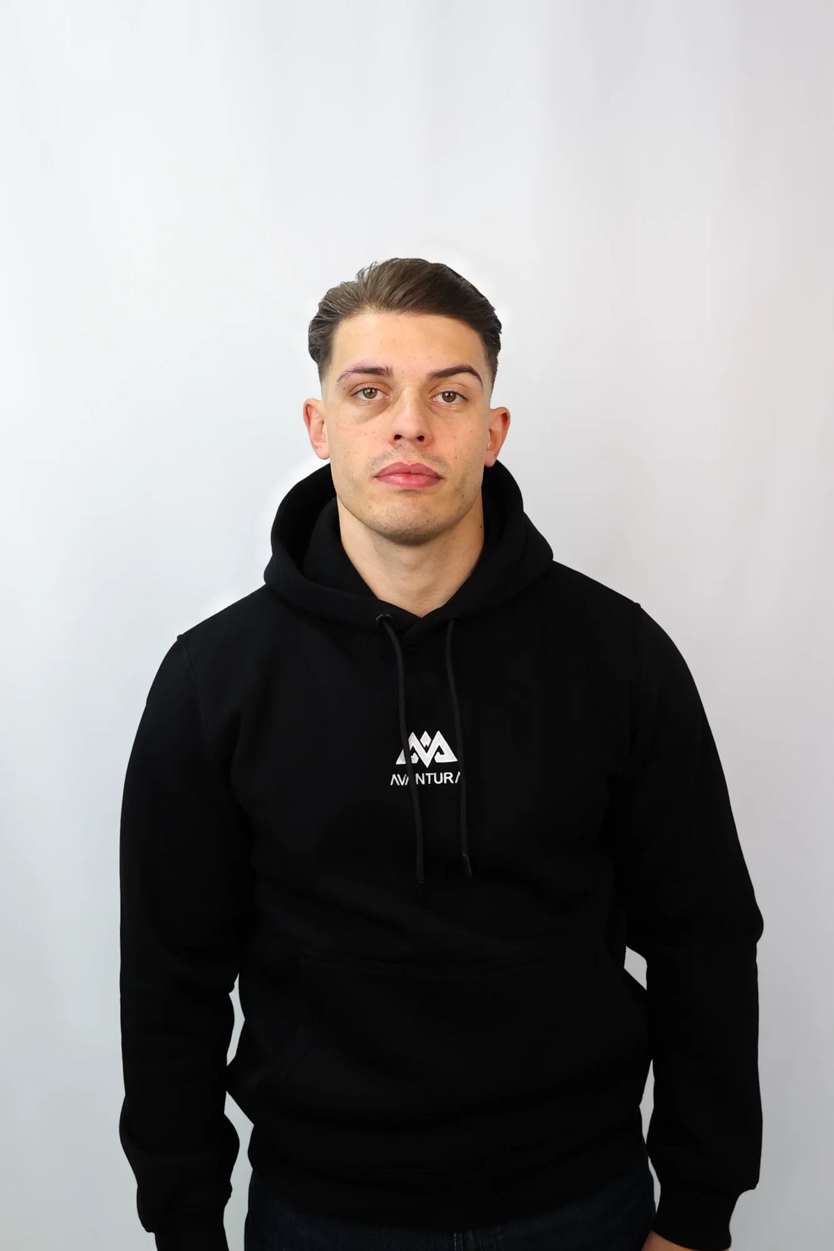 Front view of man wearing black hoodie with chest embroidery