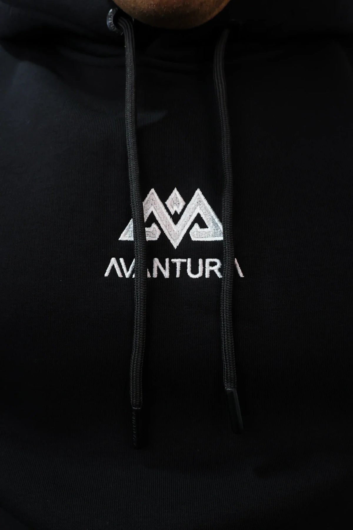 Black hoodie with white embroidered mountain logo and drawstrings