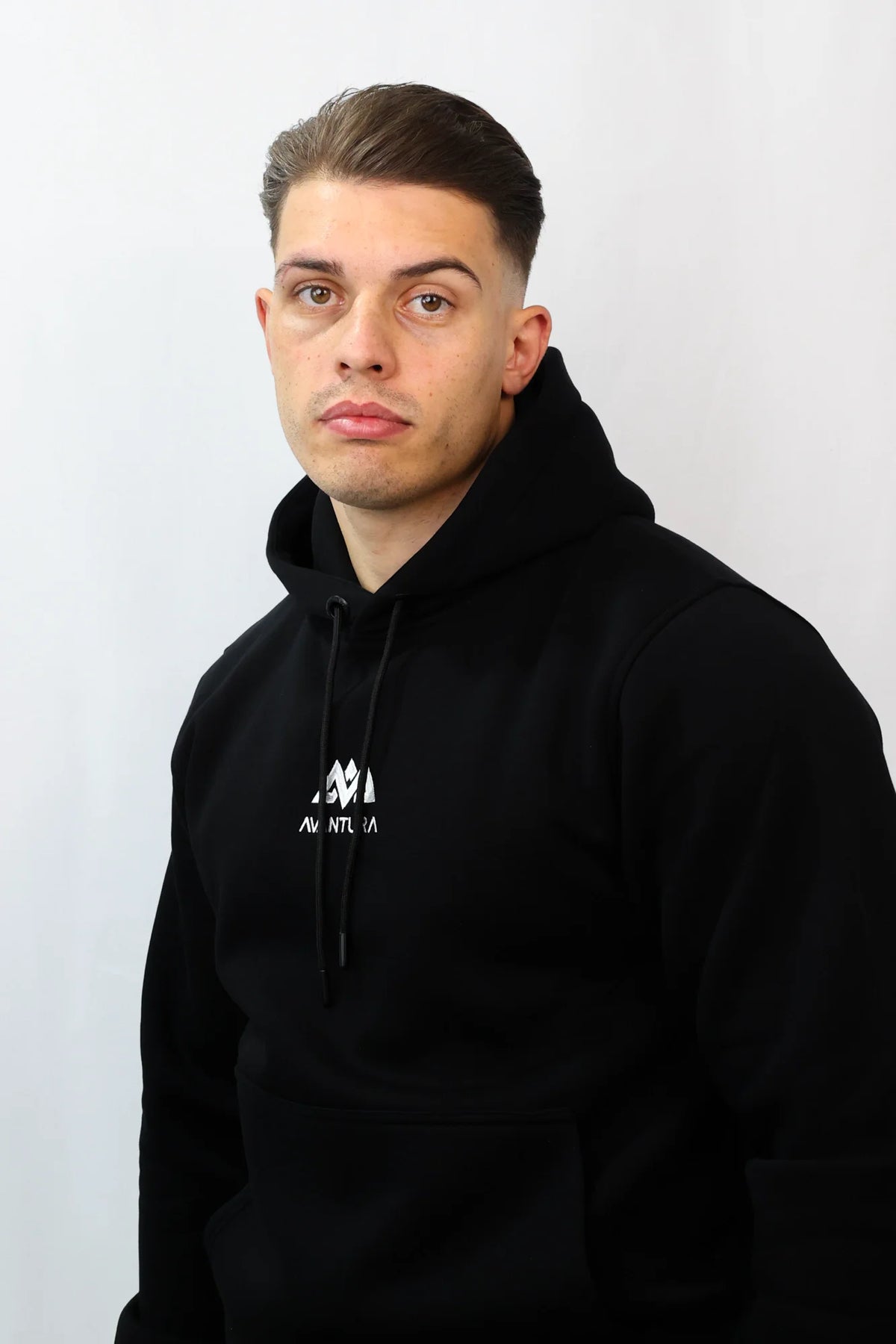 Side profile of black hoodie fit with visible chest logo