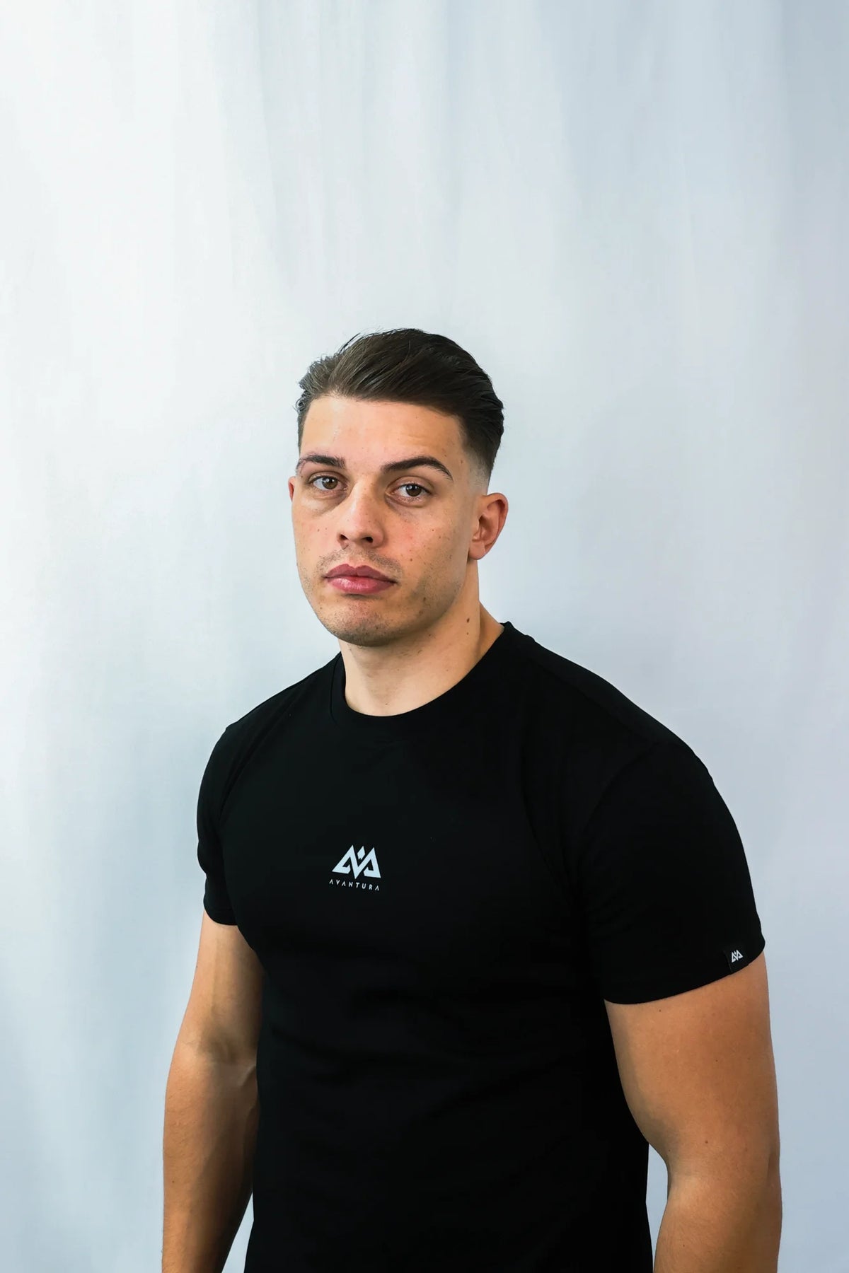 Schwarzes T-Shirt mit kleinem weißem Avantura-Logo auf der Brust