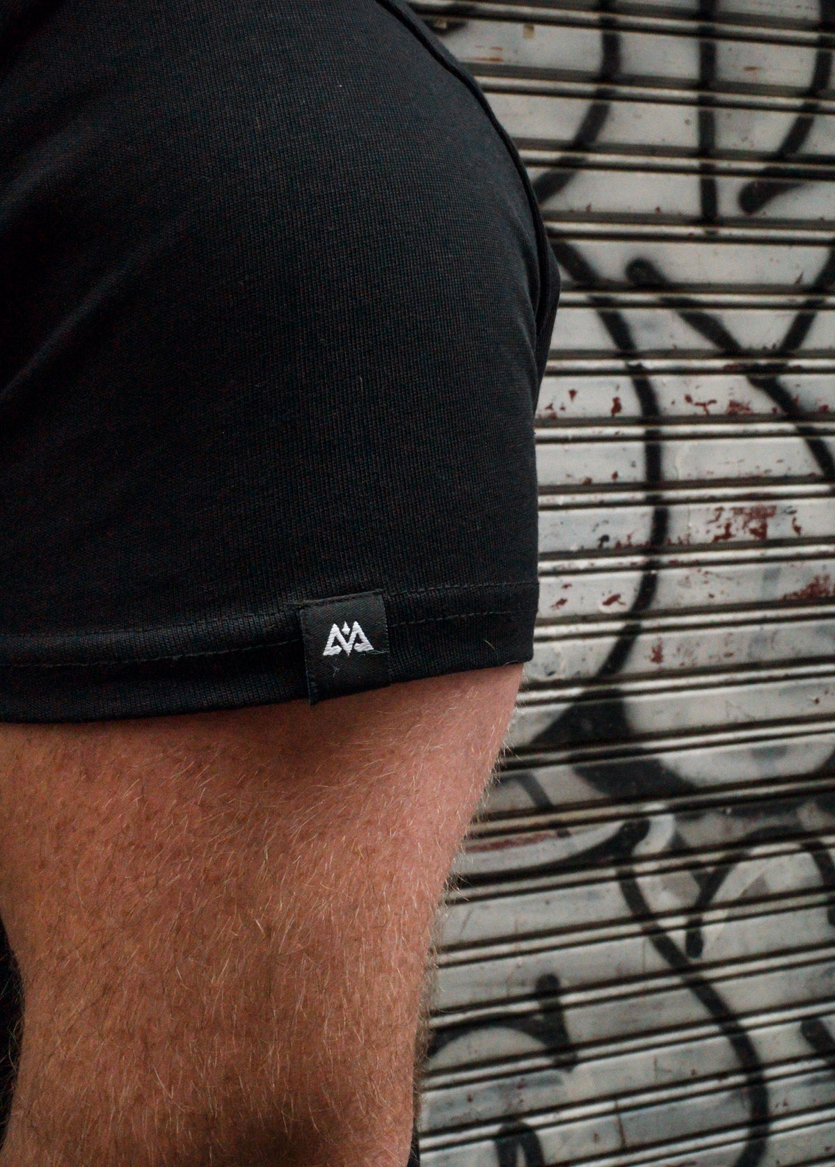 Macro shot of woven label detail on black T-shirt sleeve hem