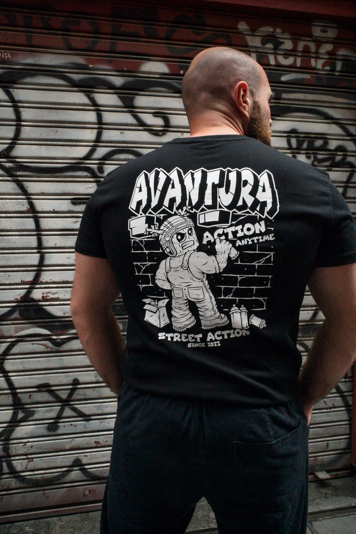 Avantura black T-shirt rear view showing stylized text and spray can illustration