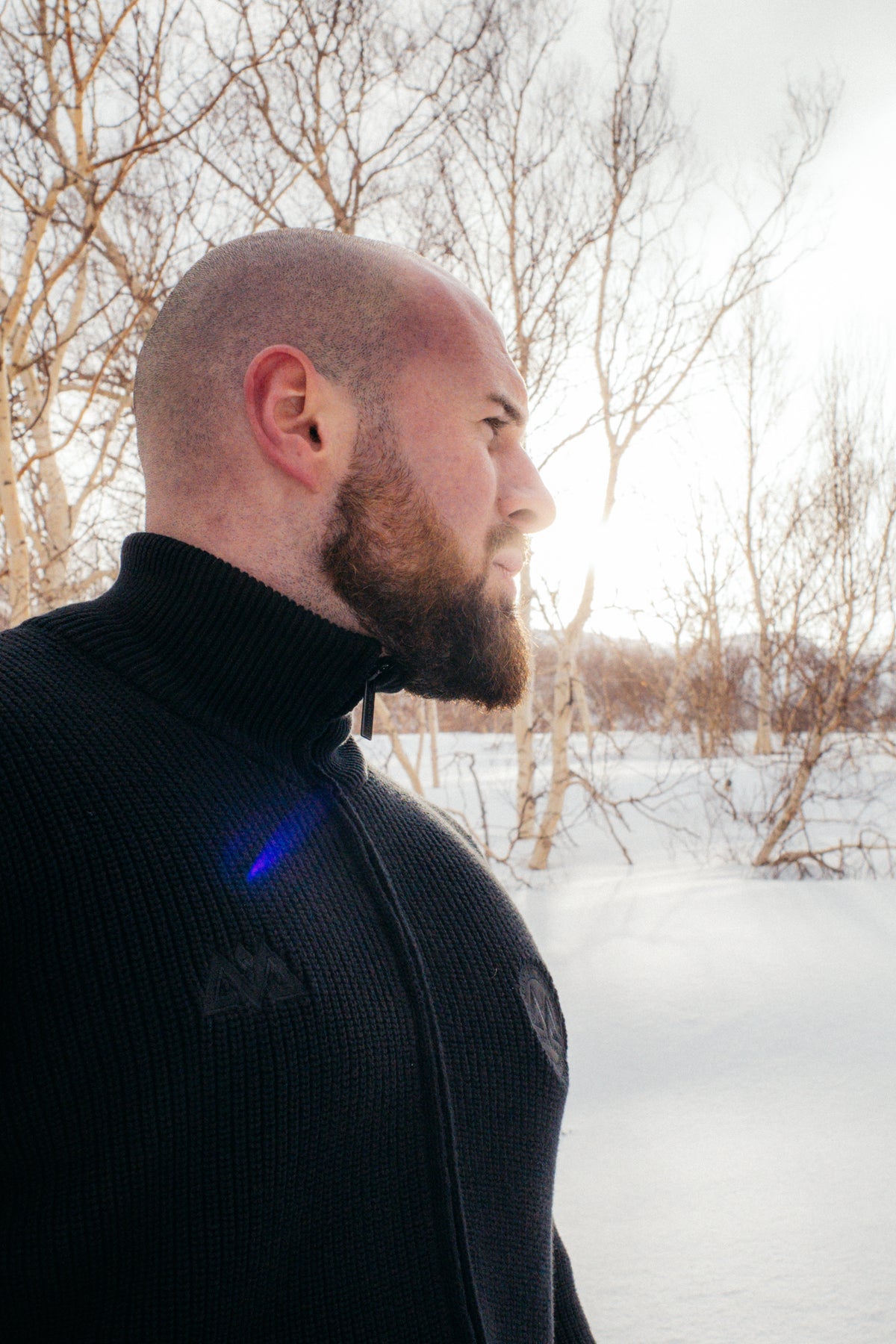 Man wearing black zip-up knit jacket outdoors