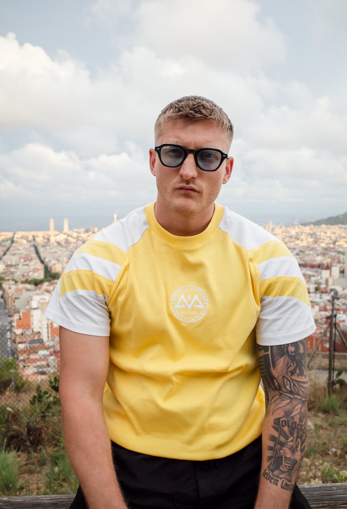 Yellow t-shirt with circular brand logo close-up