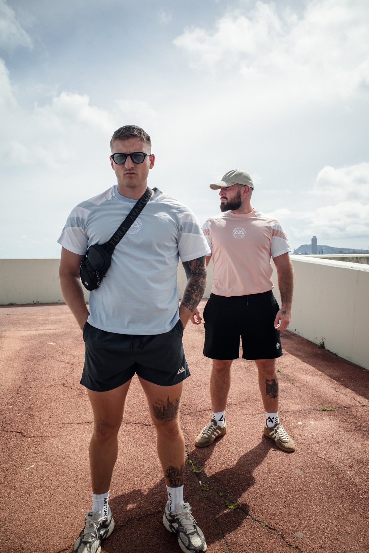 Avantura striped t-shirts in light blue and pink worn on rooftop terrace