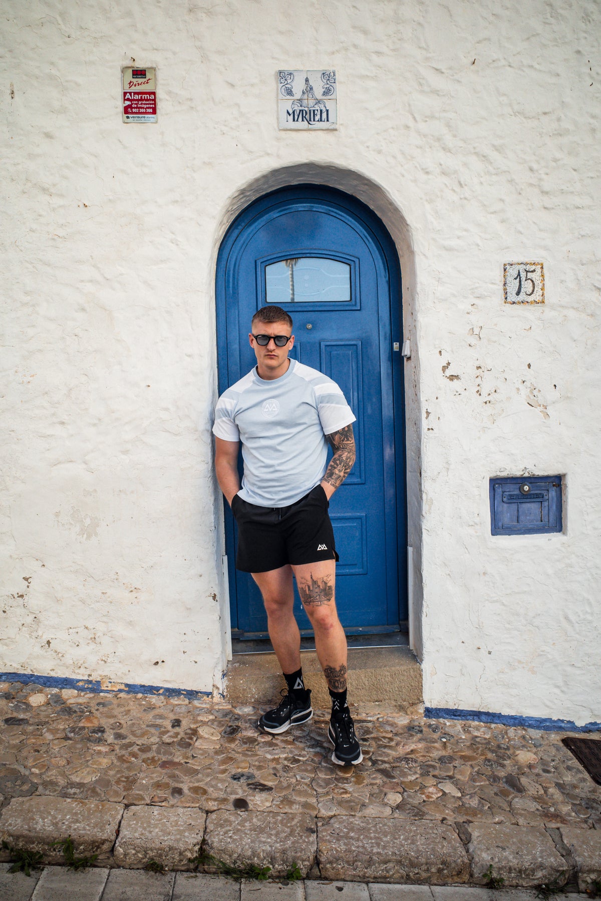 Man modeling light blue striped t-shirt with relaxed fit and chest logo