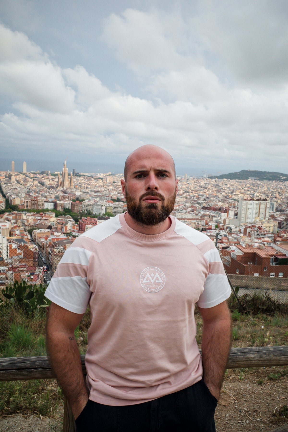 Porträt Mann in rosa-weißem Streifen-T-Shirt mit Brustlogo