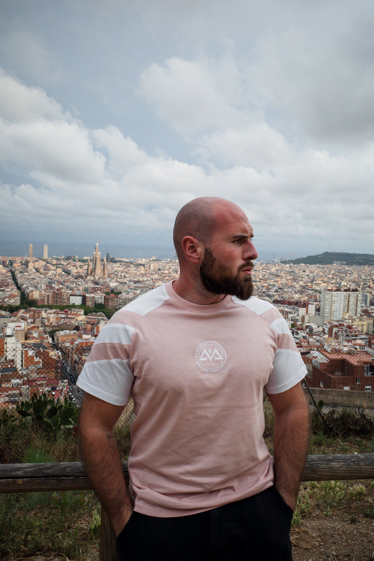 Rosa-weißes Streifen-T-Shirt mit Logo vor städtischer Skyline