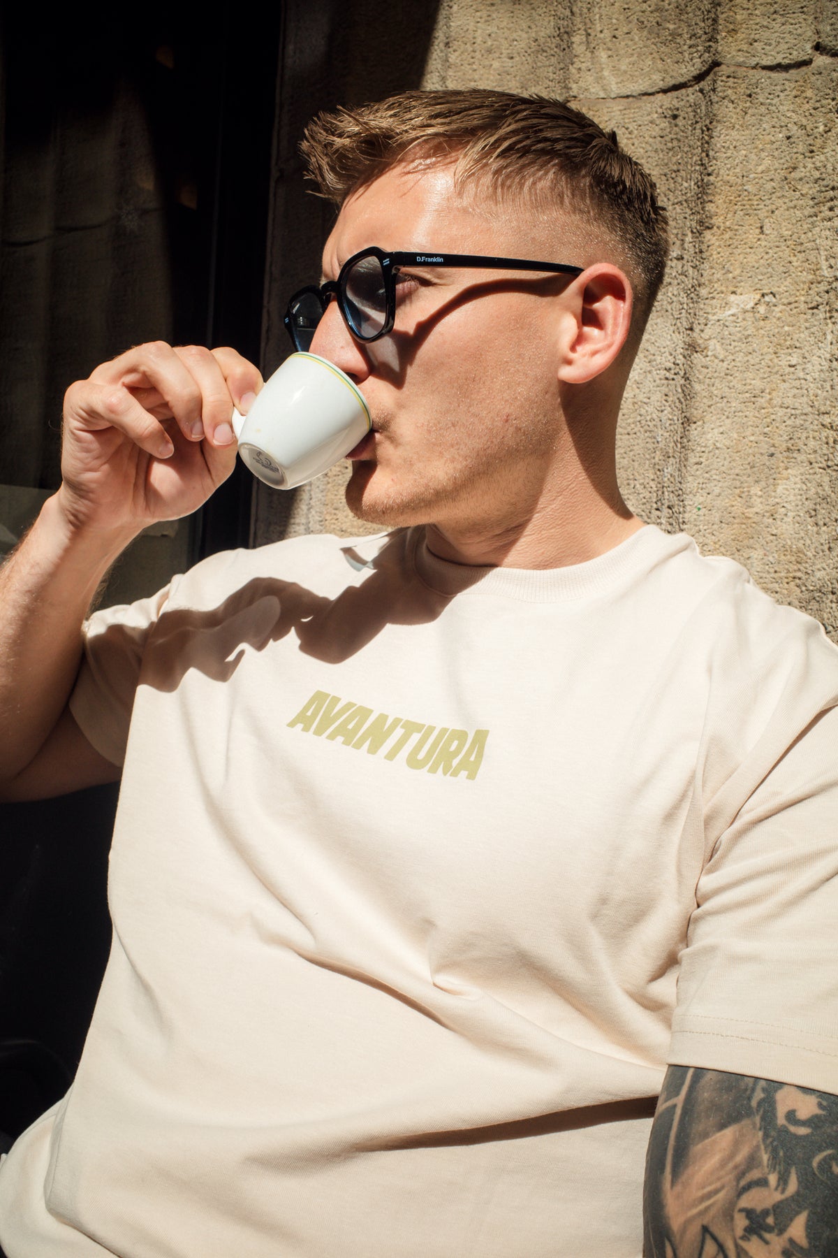 Close-up of cream oversized t-shirt with bold yellow-green Avantura print