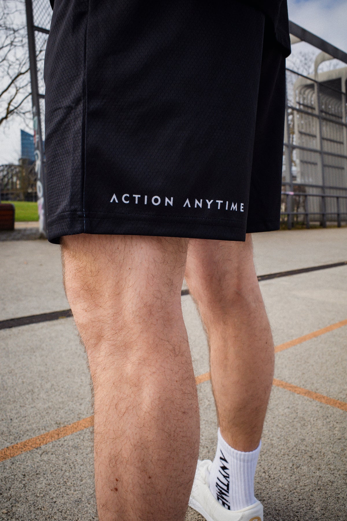 Rear hem detail of black shorts with white text print