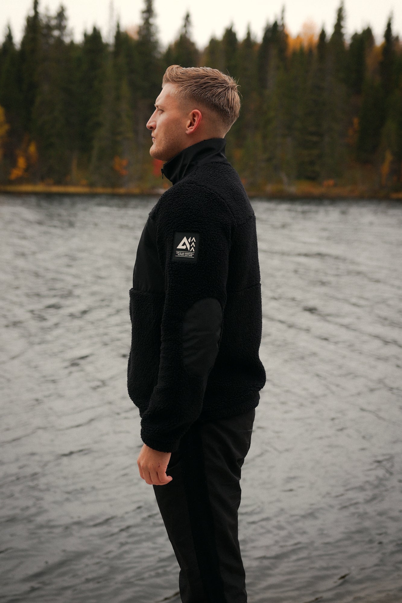 Black teddy fleece jacket with geometric logo patch and contrast fabric details