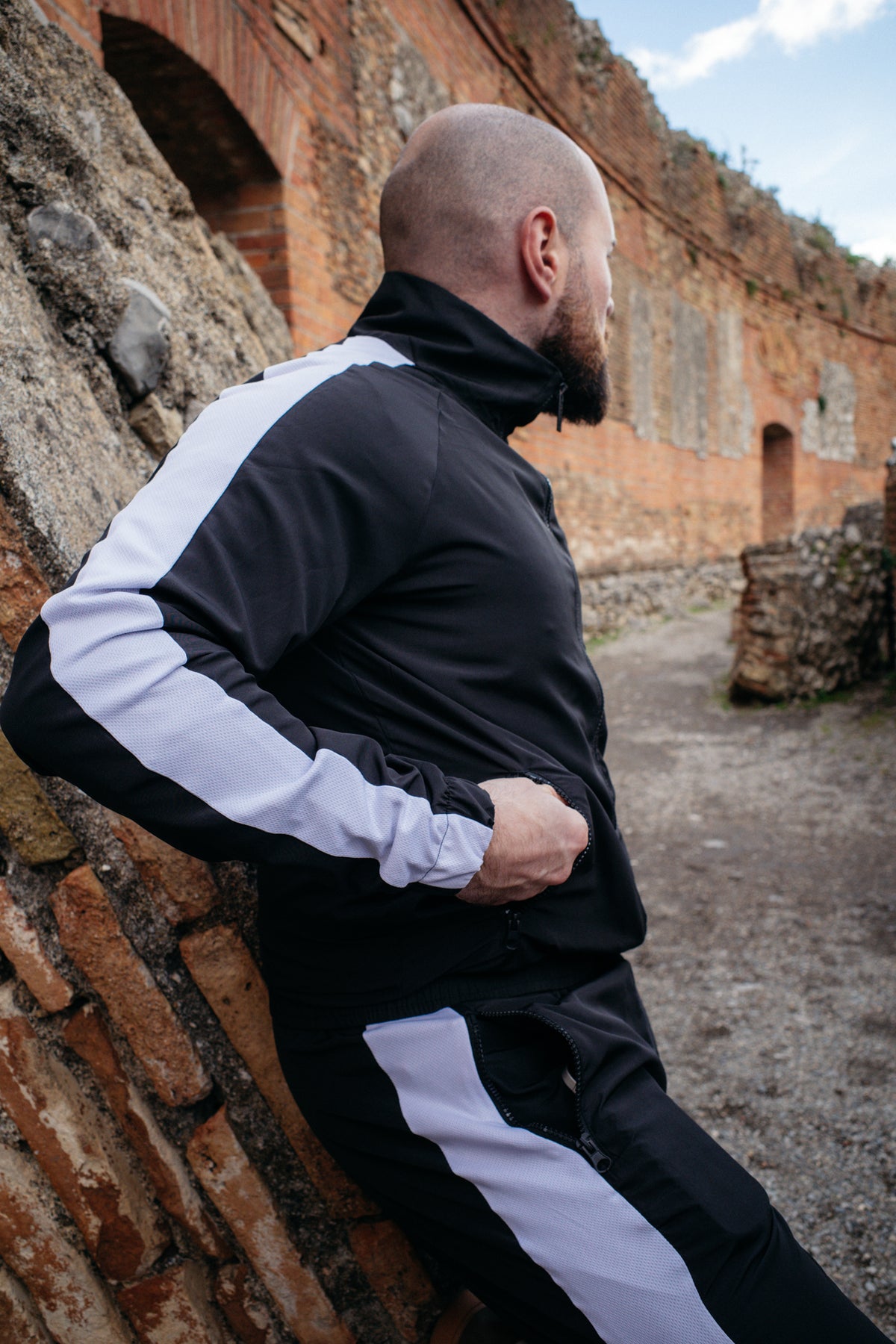 Schwarze Trackjacke mit breitem Schulterstreifen und passender Hose