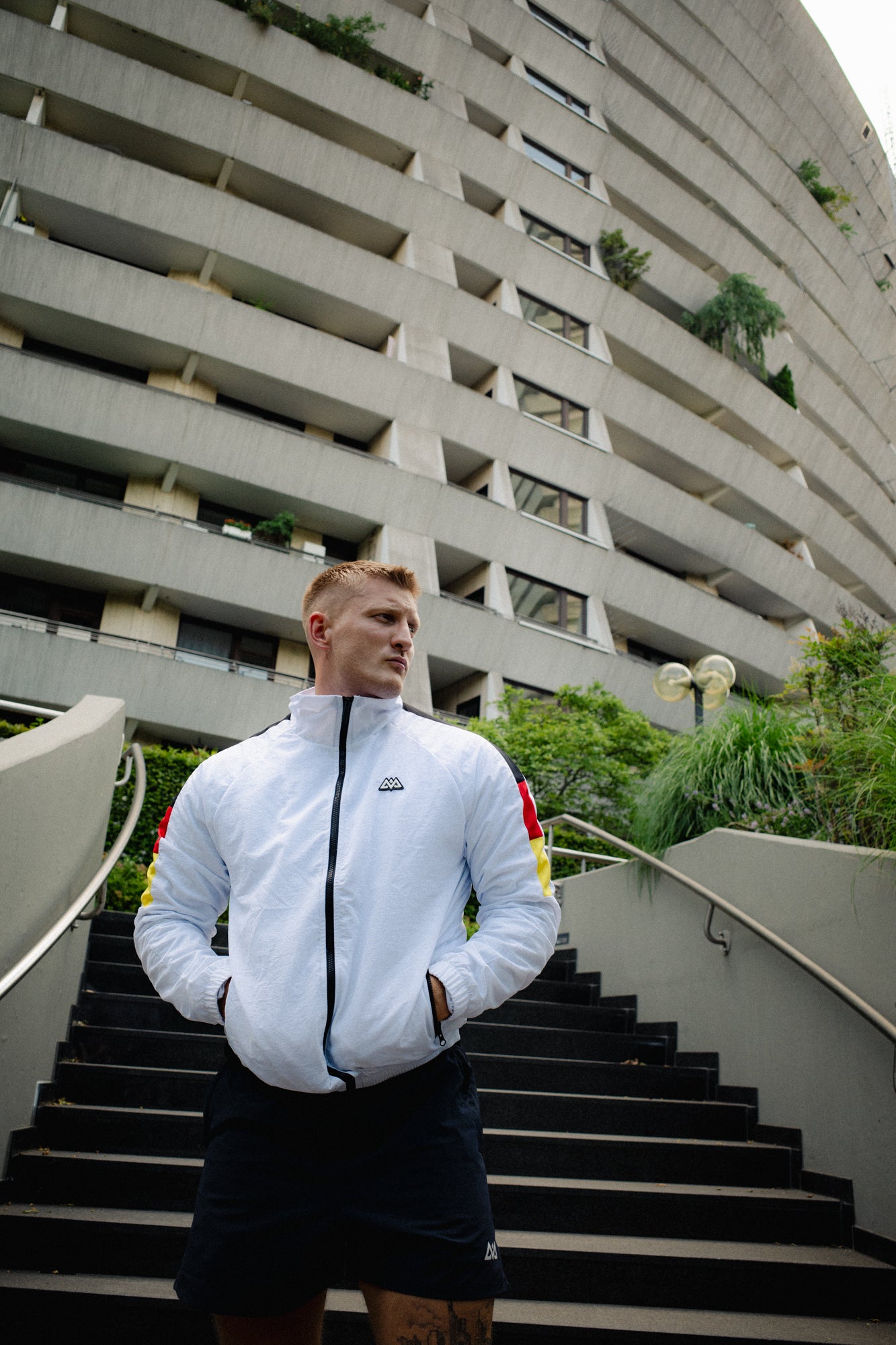 White track jacket with black red gold sleeve stripes front view