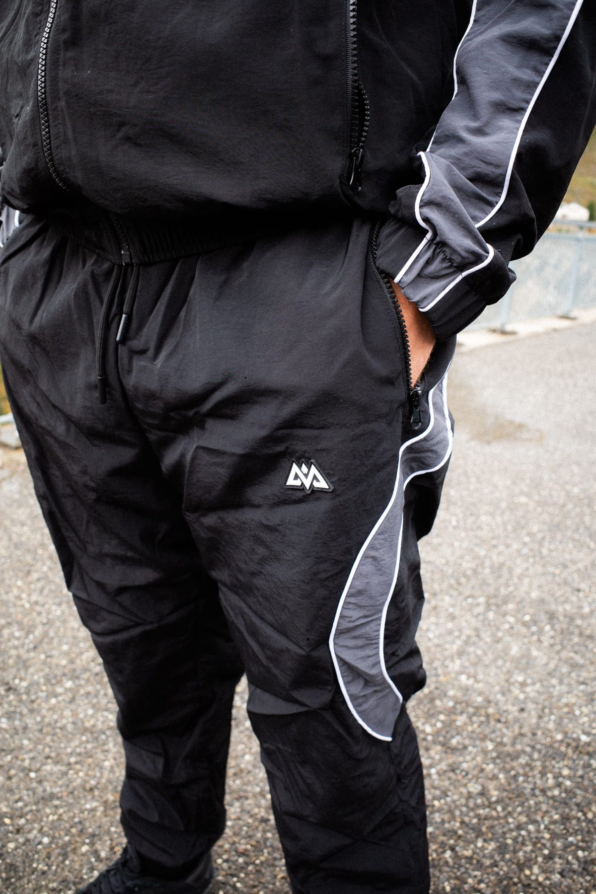 Geometrisches Logo und Reißverschlusstasche der Trackpants