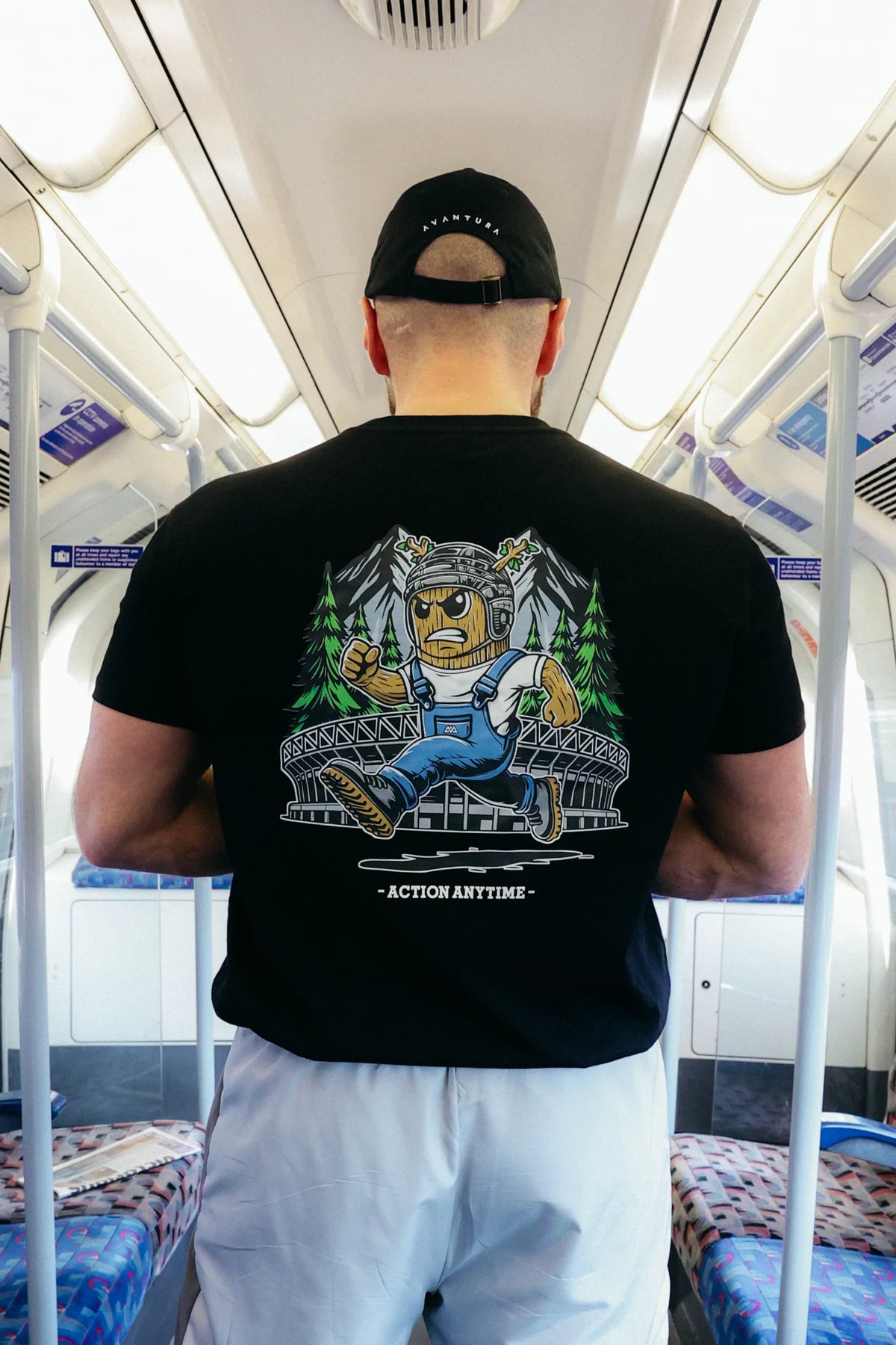 Back view of black T-shirt featuring cartoon tree trunk graphic and Action Anytime text