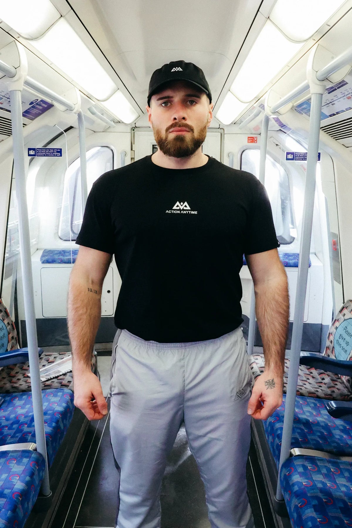 Front view of black crew neck T-shirt with geometric mountain icon and Action Anytime logo