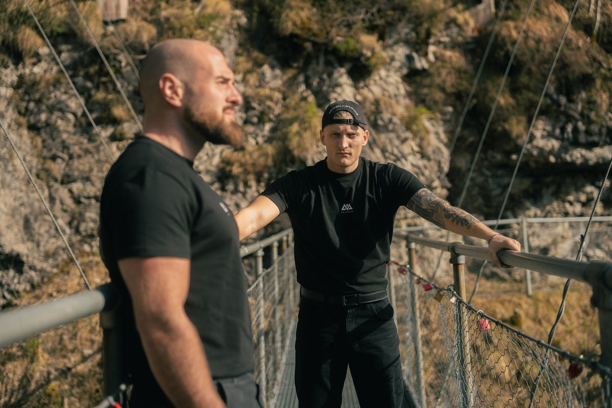 Schwarzes T-Shirt mit kleinem Brustlogo in Outdoor-Szene getragen