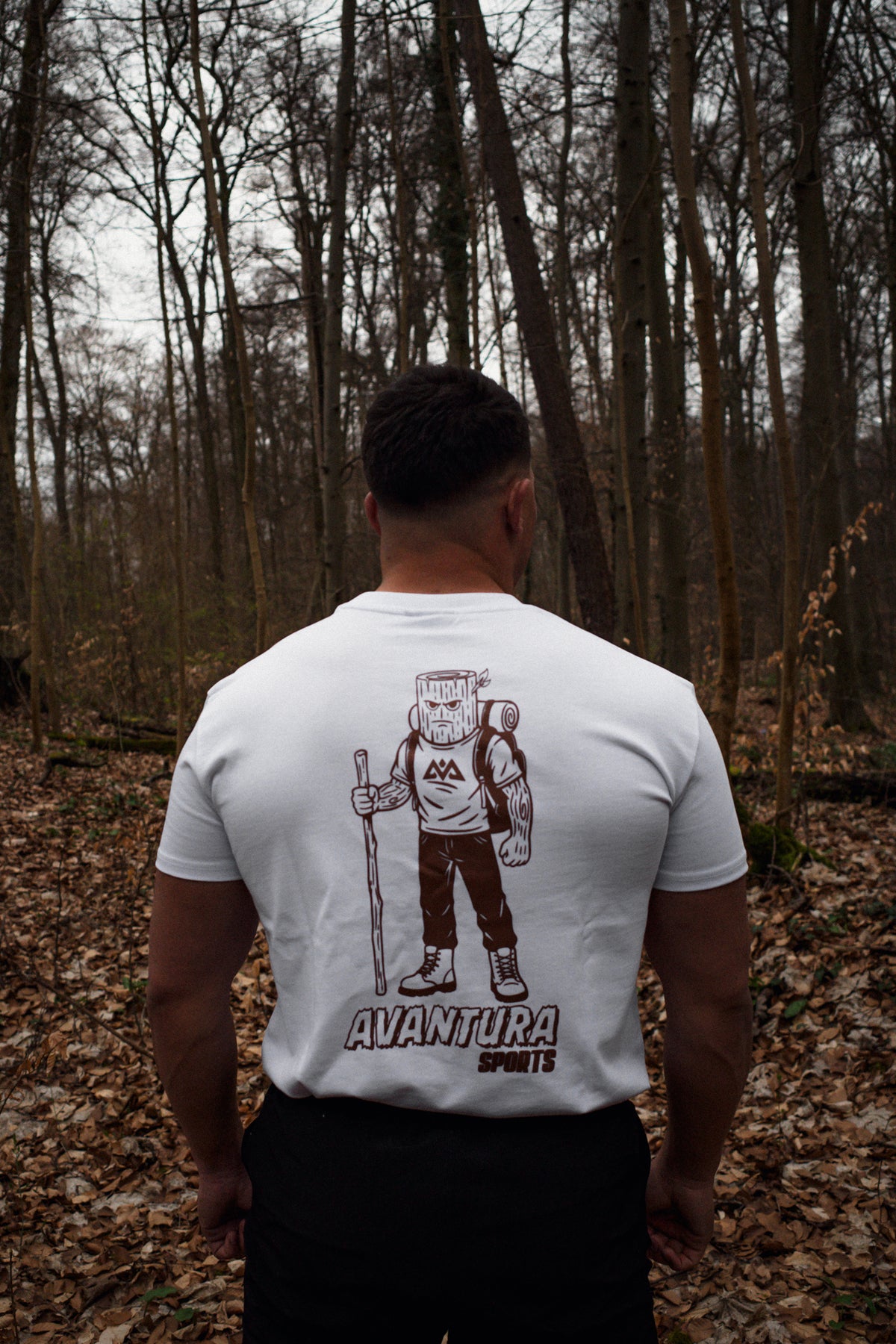 Back view of white T-shirt displaying stylized tree-stump head hiker graphic