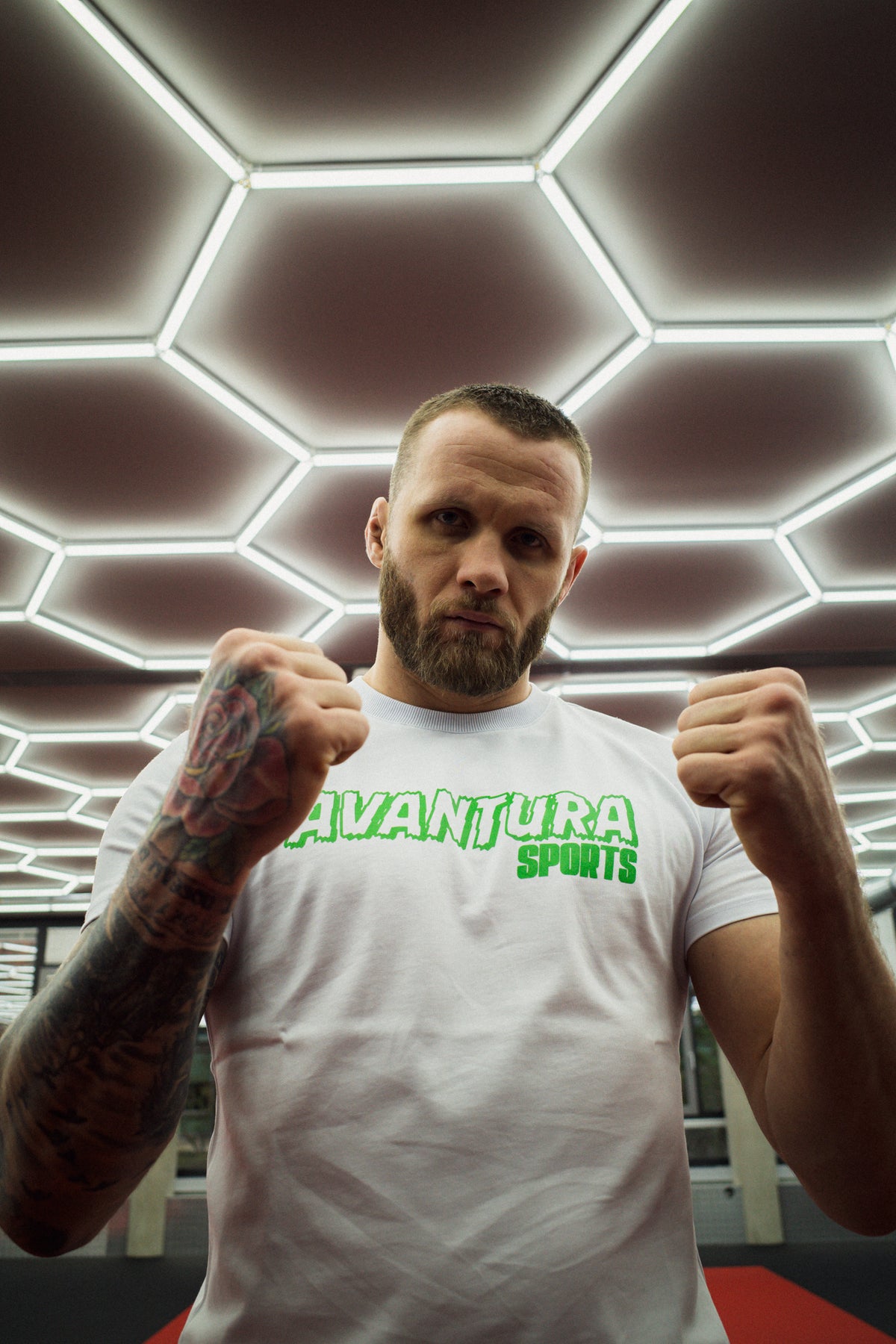 Close-up of white Avantura T-shirt with green logo in fighting pose
